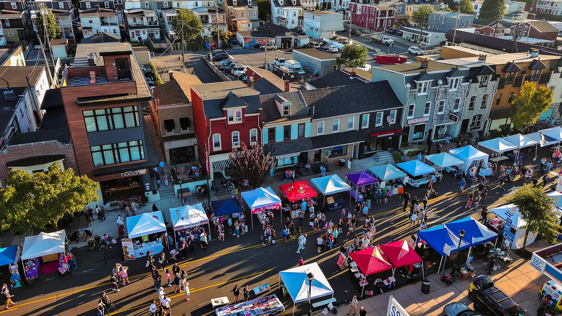 Lively street celebrations of Fall Festival. Food trucks and cafes along the street of American small town. Aerial view